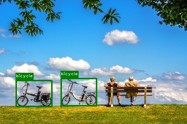Two people sitting on a bench next to two bicycles. The bicycles are labeled.